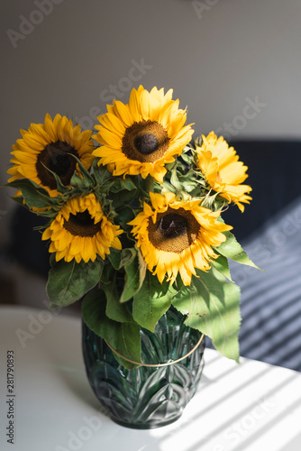 A bouquet of sunflowers in a vase on the table.