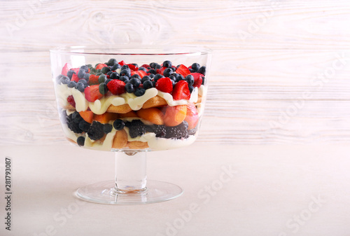 Mix berry and fruit trifle served photo