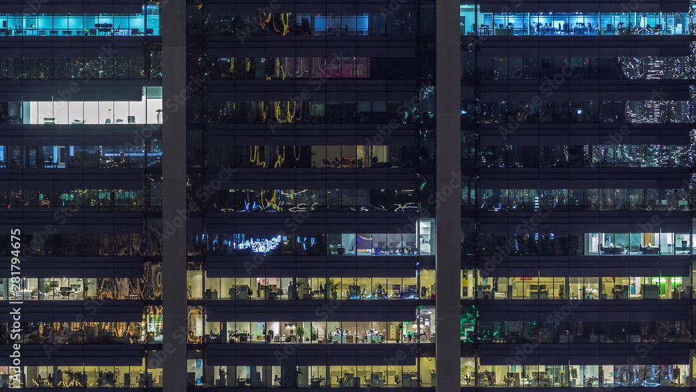 Office windows on facade of a modern skyscraper showing business activity Office windows on facade of a modern skyscraper showing business activity