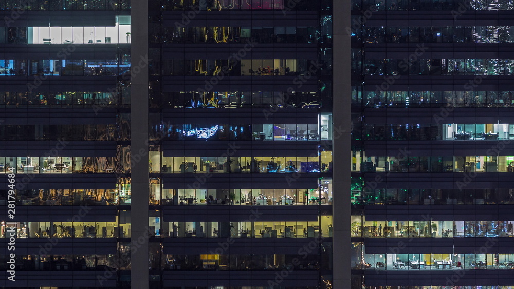 Office windows on facade of a modern skyscraper showing business activity Office windows on facade of a modern skyscraper showing business activity
