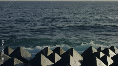 Slow motion of sea waves splashing against breakwaters photo