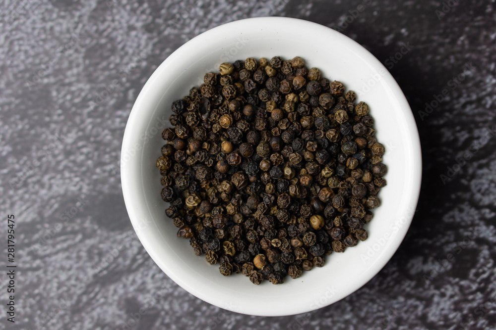 Black pepper in a bowl on dark background. Black pepper in a bowl on dark background.