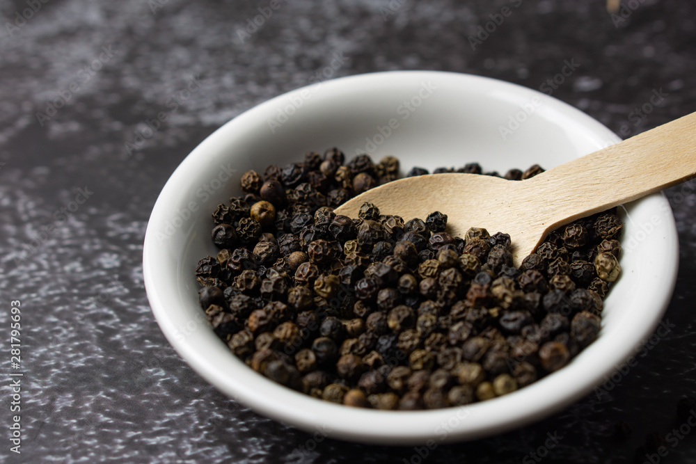 Black pepper in a bowl on dark background. Black pepper in a bowl on dark background.