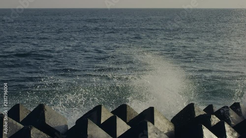 Slow motion of sea waves splashing against breakwaters photo