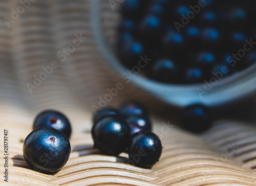 Black currant close-up in a transparent cup. There is a place for text, copy space. Background, banner, postcard.