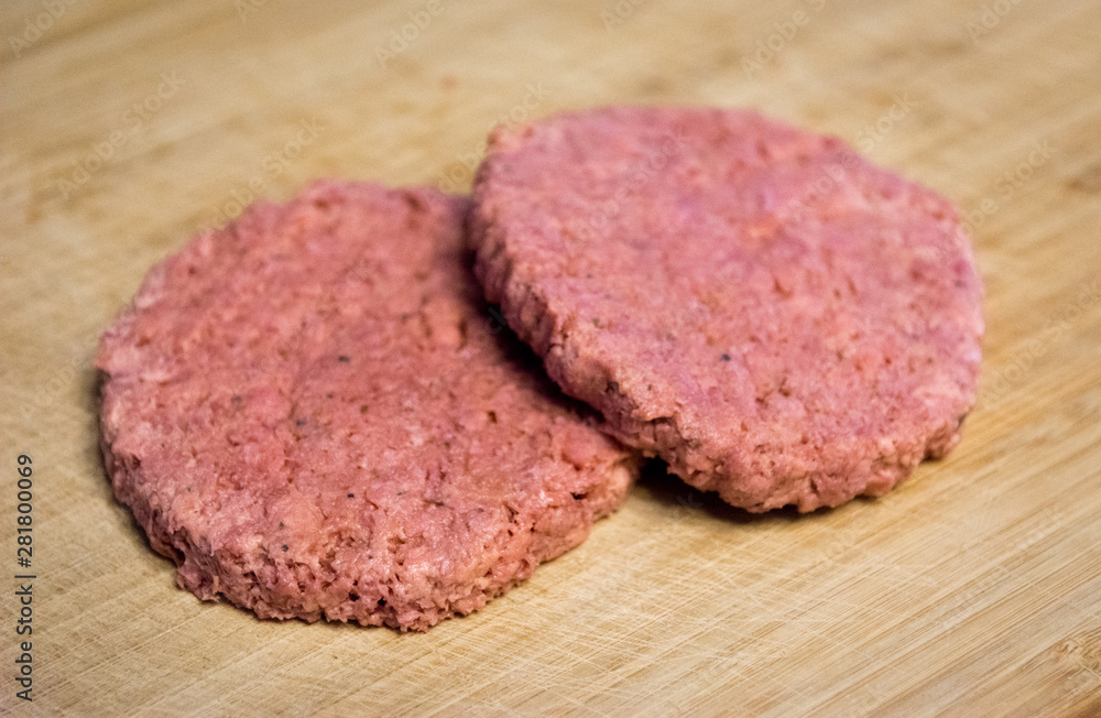 Two vegan and plant based burgers on a wooden plate Two vegan and plant based burgers on a wooden plate