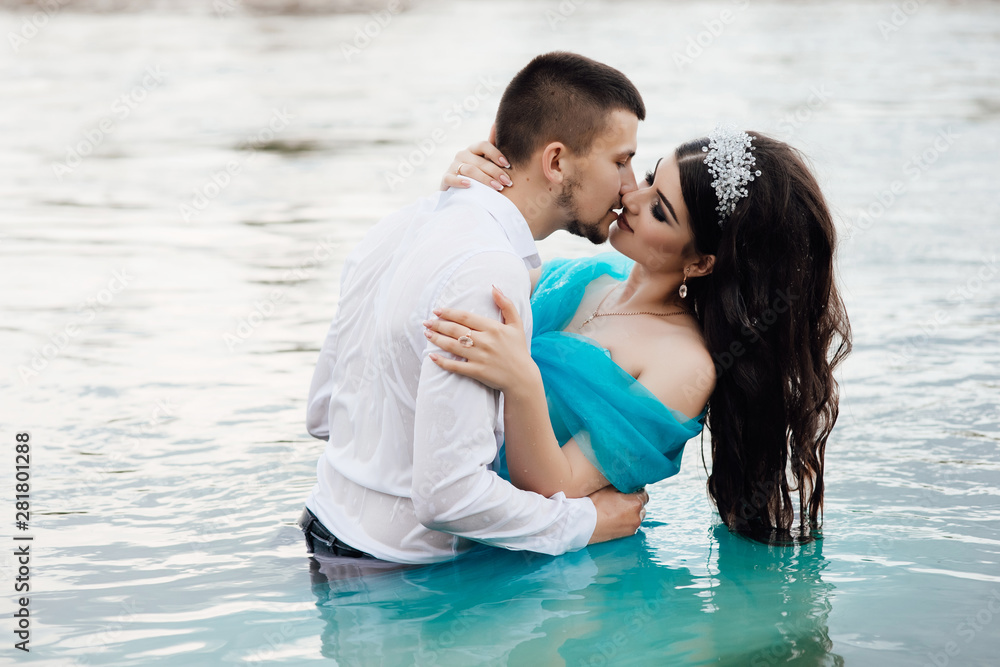 Couple in love, enjoying the summer time by the river. Holidays, vacation, love and friendship concept - smiling couple having fun on water background. Couple in love. Love story. Couple in love, enjoying the summer time by the river. Holidays, vacation, love and friendship concept - smiling couple having fun on water background. Couple in love. Love story.