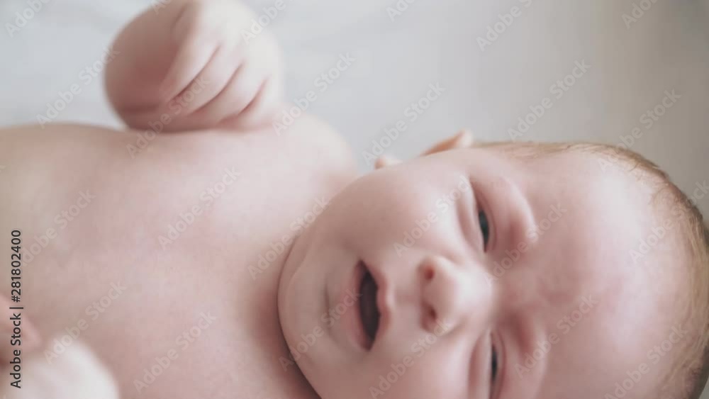 restless infant boy with plump cheeks lies on baby changing table and nurse practices hypertonus massage close view restless infant boy with plump cheeks lies on baby changing table and nurse practices hypertonus massage close view