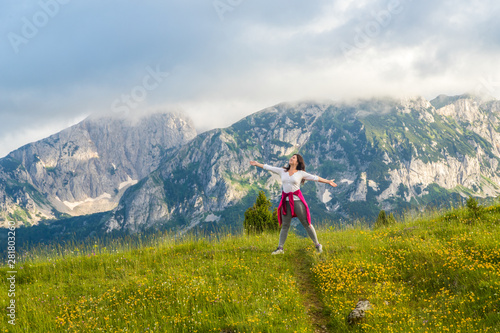 happy European girl stands on background of Montenegro mountains in Durmitor park, with copy space