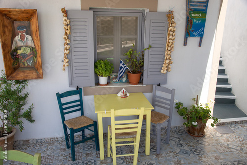 Typical Greek taverna for breakfast or lunch on the island of Santorini, Greece, in Oia. Outside terrace with window surrounded by onions, color and popular design.