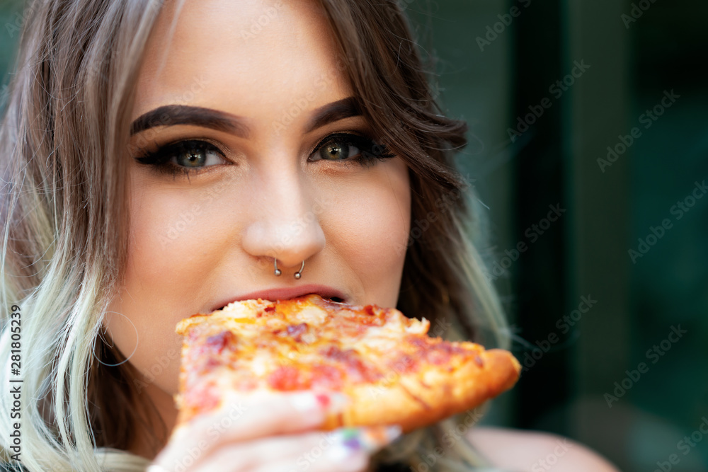 Beautiful Young Woman eating Slice of hot fresh Pizza. Popular Fast Food concept.