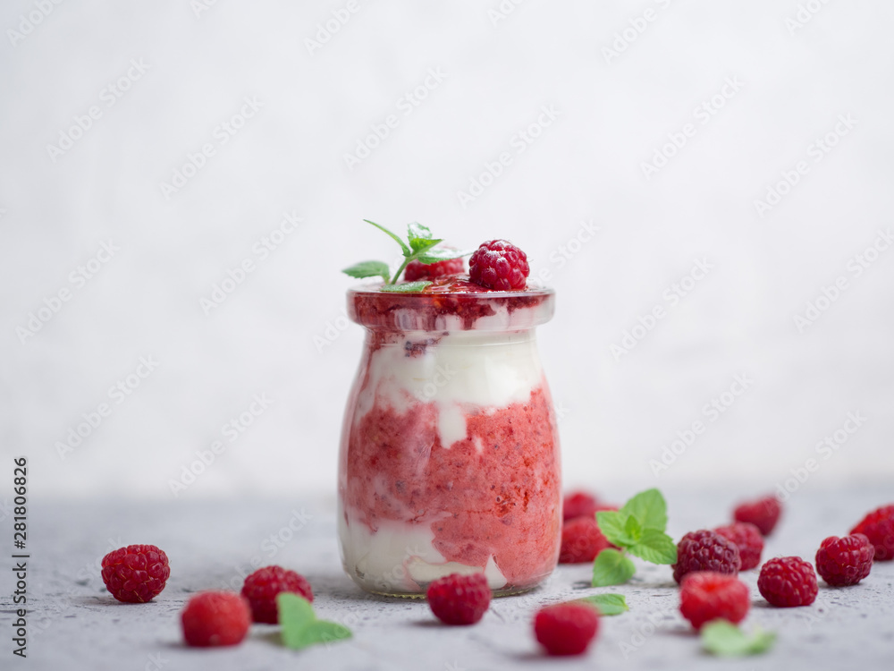 Raspberry cold summer cream dessert parfait on a grey table with mint Raspberry cold summer cream dessert parfait on a grey table with mint