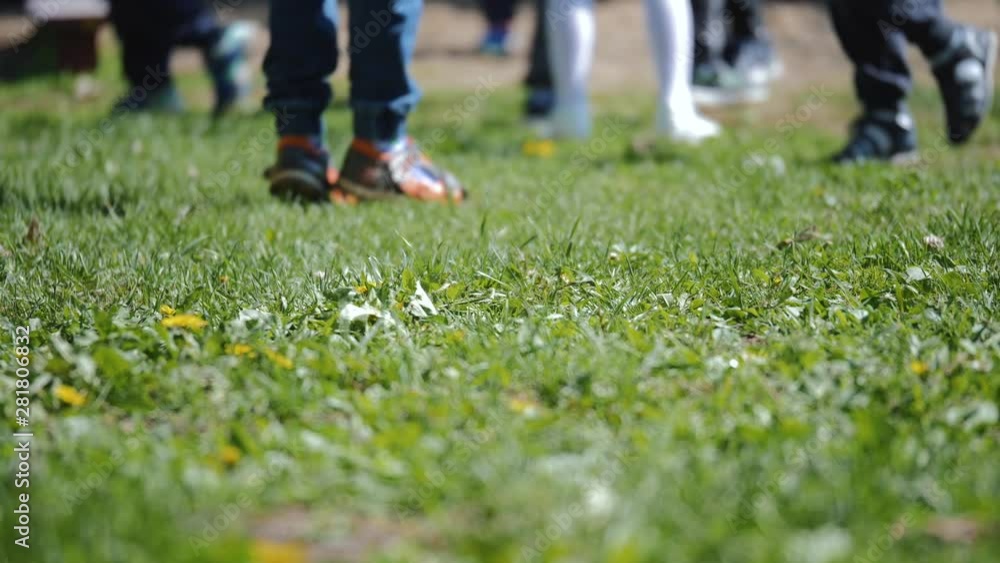 Children in the fresh air playing ball. Feet close up. Collective game. Teamwork. Children in the fresh air playing ball. Feet close up. Collective game. Teamwork.