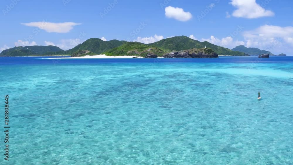 Drone view of people paddle boarding near Zamami Island Drone view of people paddle boarding near Zamami Island