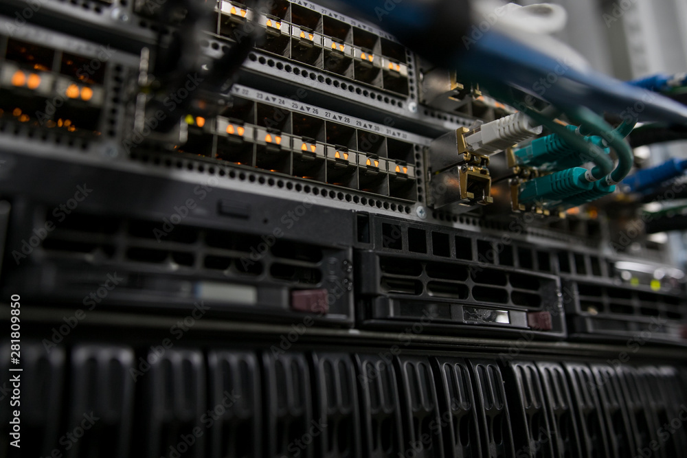 Fiber Optical connector interface. Fibre Channel swich. Severs computer in a rack at the large data center. Fiber Optical connector interface. Fibre Channel swich. Severs computer in a rack at the large data center.