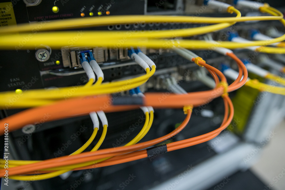 Server rack with red internet patch cord cables connected to patch panel in server room Server rack with red internet patch cord cables connected to patch panel in server room