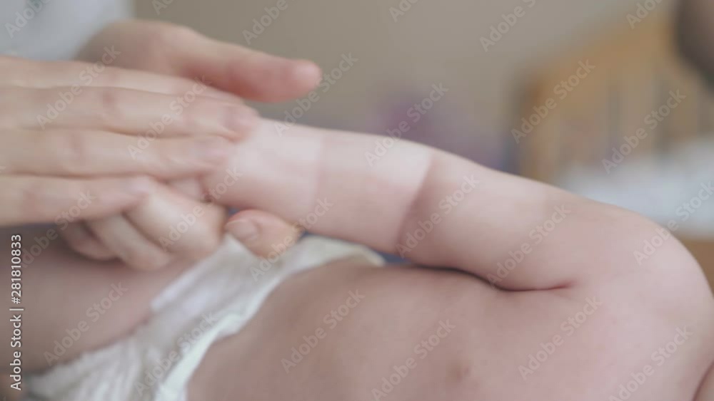 newborn baby in white diaper lies on special table and enjoys professional hypertonus arms massage extreme close view newborn baby in white diaper lies on special table and enjoys professional hypertonus arms massage extreme close view