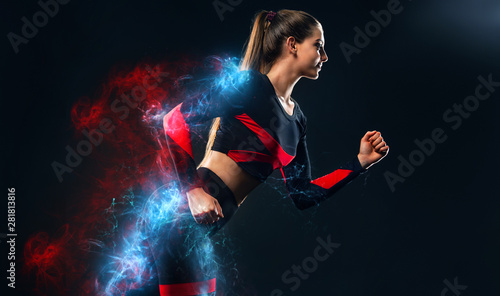 Strong athletic woman sprinter, running on black background wearing in the sportswear and headphones. Fitness and sport motivation. Runner concept.