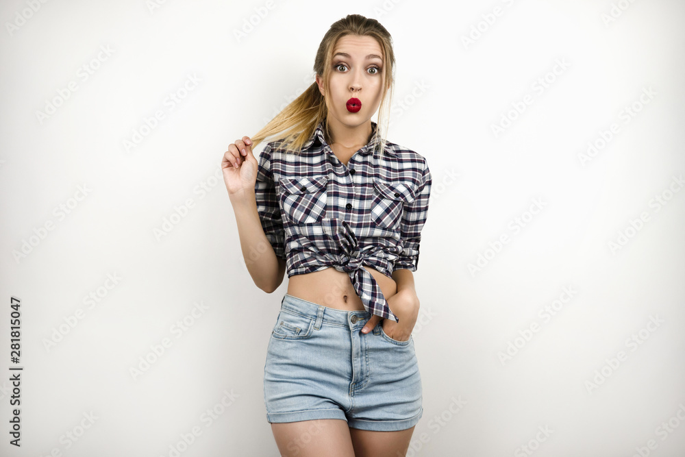 young beautiful blonde woman wearing trendy checkered shirt and denim shorts posing for clothes shop advertisement isolated white background young beautiful blonde woman wearing trendy checkered shirt and denim shorts posing for clothes shop advertisement isolated white background