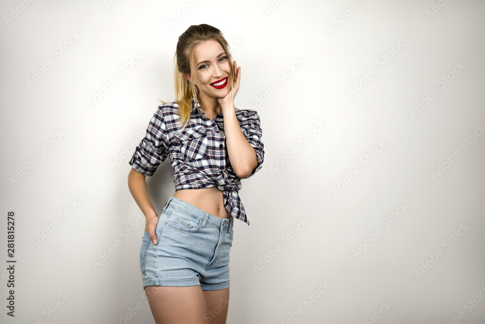 young beautiful blonde woman wearing trendy checkered shirt and denim shorts looking cute isolated white background young beautiful blonde woman wearing trendy checkered shirt and denim shorts looking cute isolated white background