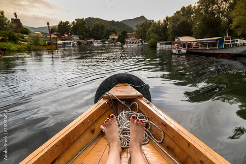 female feet on the bow of the floating boat close up on the lake Lake Skadar National Park Montenegro