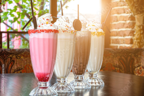 Four different milkshakes on a table in a cafe