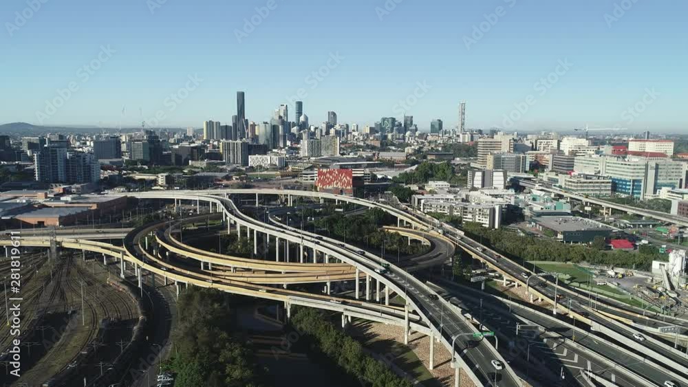 Busy skyline aerial point of view. Highways, skyscrapers, road system, tunnel, cars, freight, train tracks with the city in the background at sunrise in Brisbane Busy skyline aerial point of view. Highways, skyscrapers, road system, tunnel, cars, freight, train tracks with the city in the background at sunrise in Brisbane