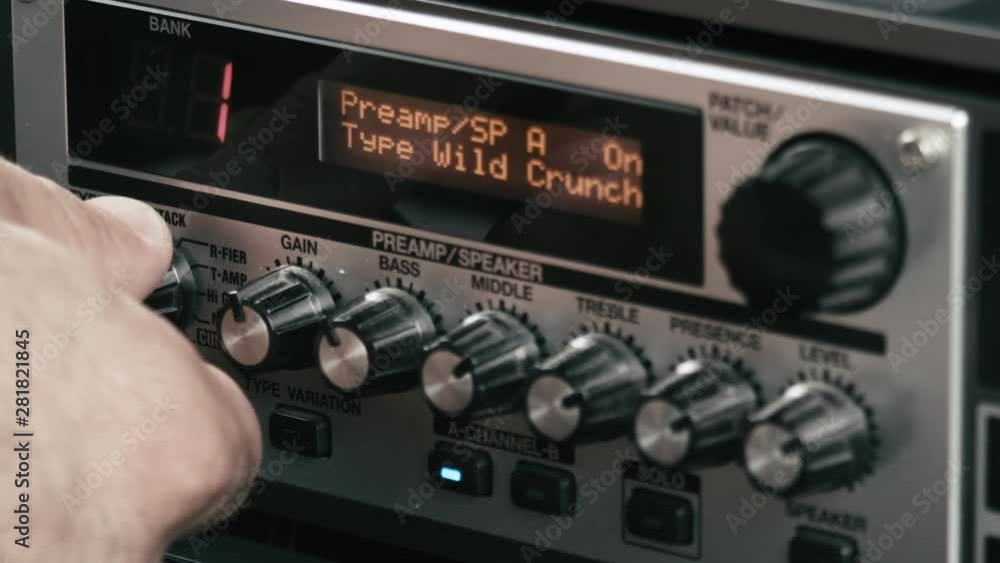 Musician's hand changes speaker settings of a guitar preamp multi effect, close up. Musician's hand changes speaker settings of a guitar preamp multi effect, close up.