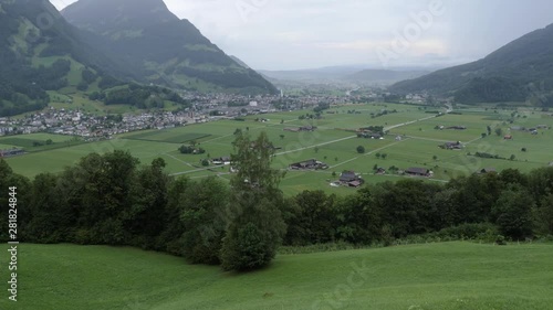 Perspective view of the Linth rivers valley surrounded by alpine montains near Glarus Nord in Switzerland. Scenic shot taken from hill-side on a cloudy day with the valley and mountains in foreground. photo