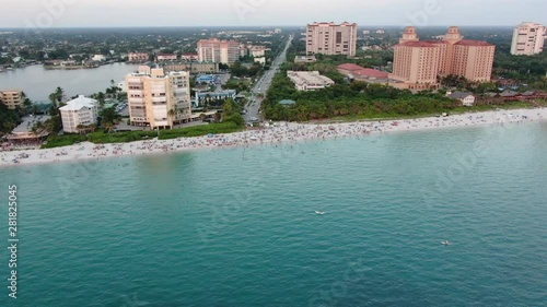 Drone Aerial of a crowded beach zooming in to a pile of paddle boards photo