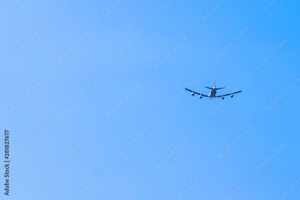 blue clear sky and silhouette of a flying plane blue clear sky and silhouette of a flying plane