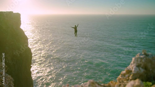 Slackliner trying to keep his balance on a bouncing line photo