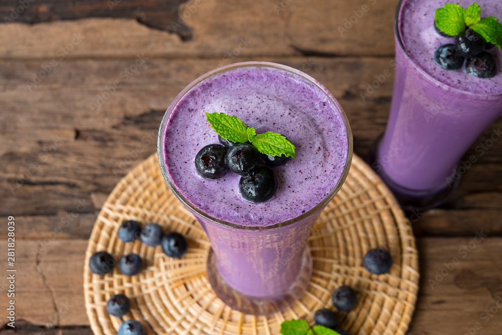 Blueberry smoothies purple colorful fruit juice milkshake blend beverage healthy high protein the taste yummy In glass drink episode morning on wood background. Blueberry smoothies purple colorful fruit juice milkshake blend beverage healthy high protein the taste yummy In glass drink episode morning on wood background.