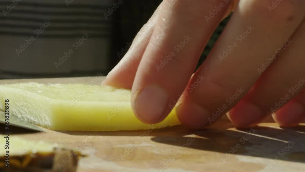 Closeup shallow focus shot on a pineapple being cut into small pieces Closeup shallow focus shot on a pineapple being cut into small pieces