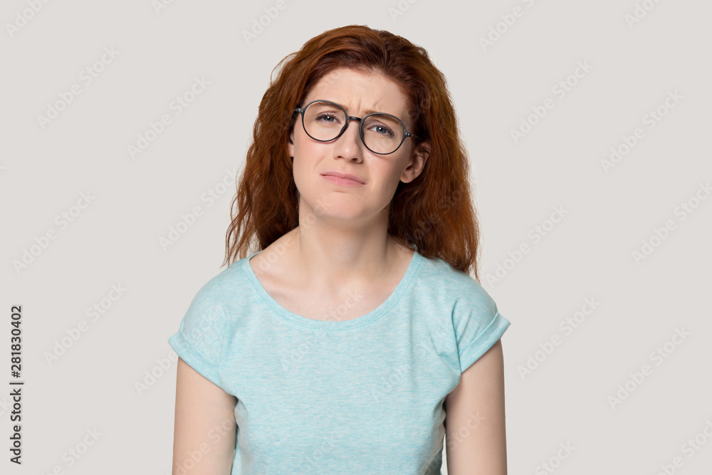 Unhappy upset face expressions redhead woman isolated on grey background