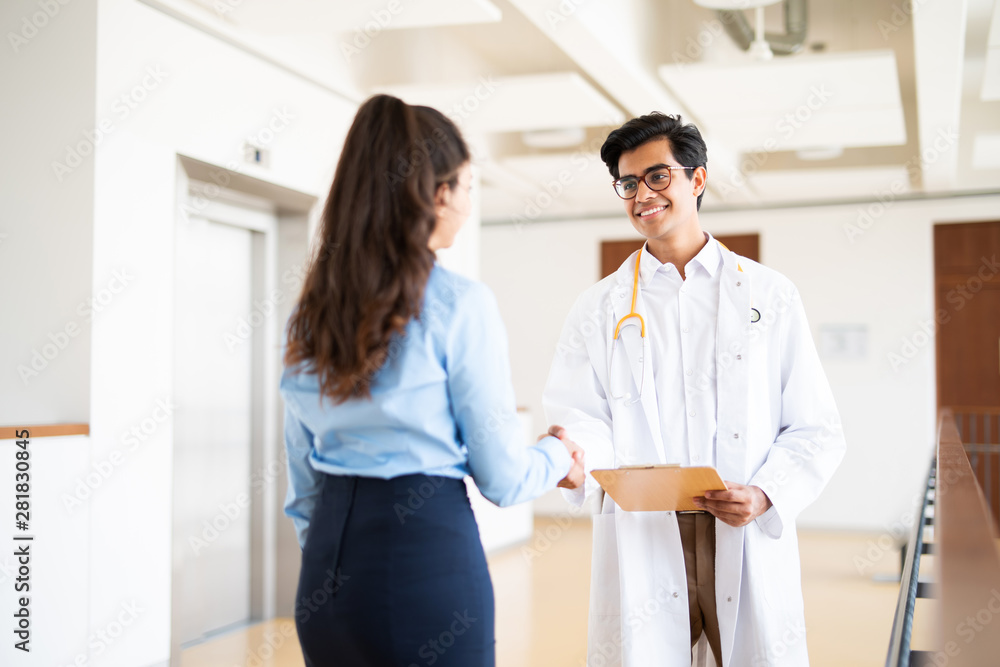Arzt im Krankenhaus begrüßt eine Patientin Arzt im Krankenhaus begrüßt eine Patientin