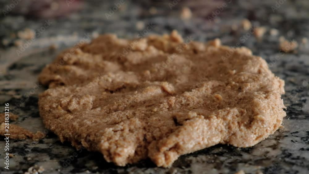 Handheld close up of stretched whole wheat cookie dough on countertop Handheld close up of stretched whole wheat cookie dough on countertop