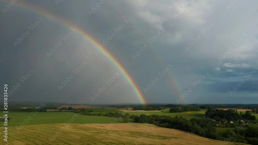 Rainbow Above Wheat Field. Flight Down Ripe Crop Field After Rain and Colorfull Rainbow in Background Rural Countryside. Areal Dron Shoot. Rainbow Above Wheat Field. Flight Down Ripe Crop Field After Rain and Colorfull Rainbow in Background Rural Countryside. Areal Dron Shoot.