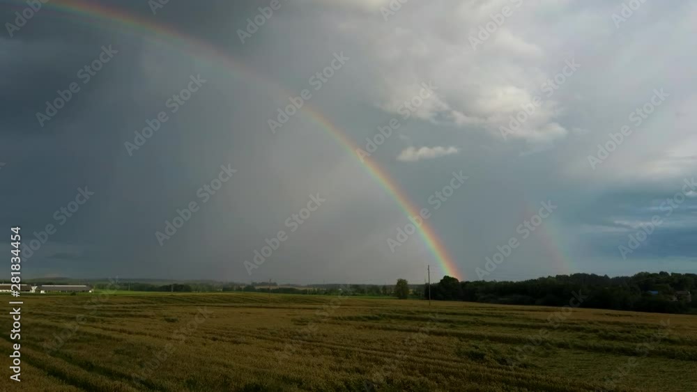 Rainbow Above Wheat Field. Flight Above Ripe Crop Field After Rain and Colorfull Rainbow in Background Rural Countryside. Areal Dron Shoot. Rainbow Above Wheat Field. Flight Above Ripe Crop Field After Rain and Colorfull Rainbow in Background Rural Countryside. Areal Dron Shoot.