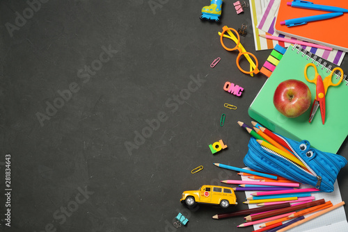 Back to School concept - office and student supplies on black chalk background. Space for text.