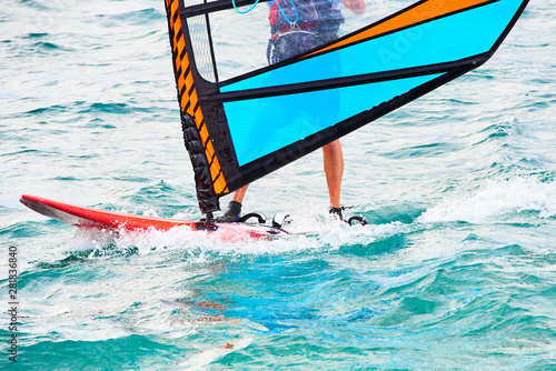 Windsurfing details. A windsurfer rides on the sea