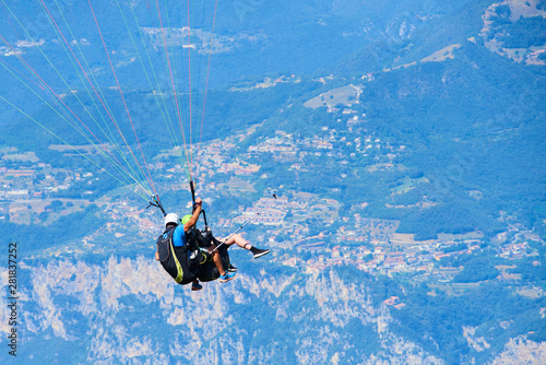 Paraglider flying over the Garda Lake Panorama of the gorgeous Garda lake surrounded by mountains. Paragliding is very popular sport in Monte Baldo. 