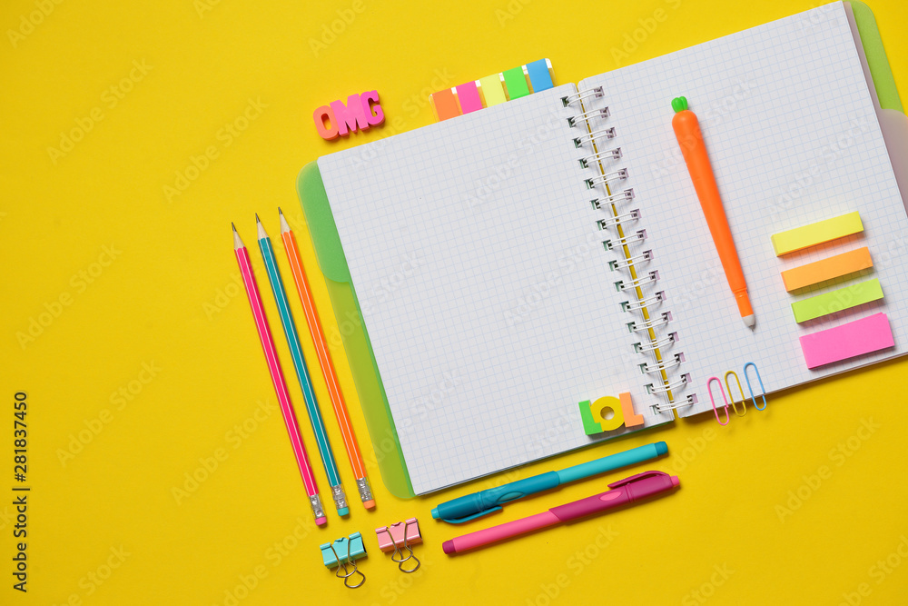 Colorful Back to School concept - open copy book with office and student supplies on yellow chalk. Space for text. Colorful Back to School concept - open copy book with office and student supplies on yellow chalk. Space for text.