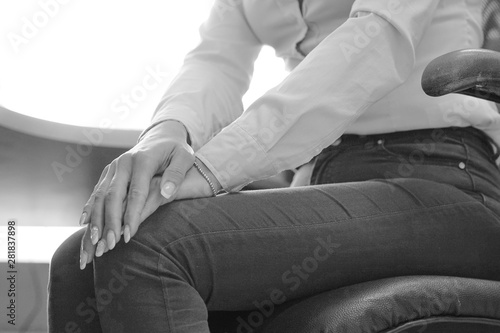 Black and white image of office worker Female Leg With Painful Knees. Woman Feeling Joint Pain, Having Health Issues And Touching Leg With Hands. Body And Health Care Concept.