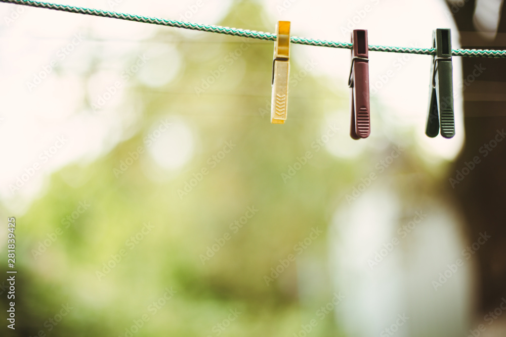 Close up clothes pin on a green background. Plastic clothes pegs on green rope. Close up clothes pin on a green background. Plastic clothes pegs on green rope.