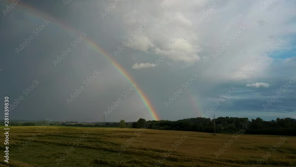 Rainbow Above Wheat Field. Flight Sideward Ripe Crop Field After Rain and Colorfull Rainbow in Background Rural Countryside. Aerial Dron Shot. Rainbow Above Wheat Field. Flight Sideward Ripe Crop Field After Rain and Colorfull Rainbow in Background Rural Countryside. Aerial Dron Shot.