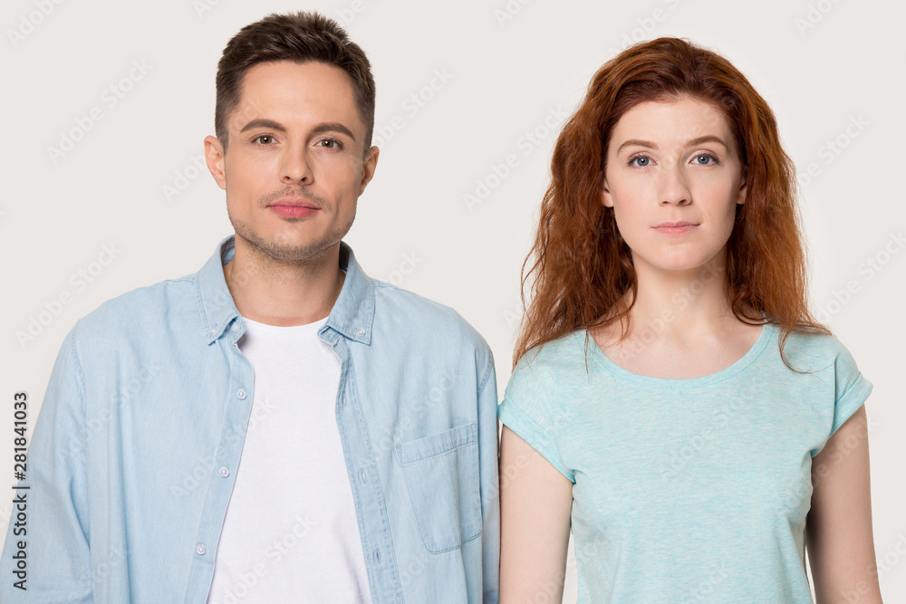 Headshot portrait millennial serious girl and guy isolated on grey Headshot portrait millennial serious girl and guy isolated on grey