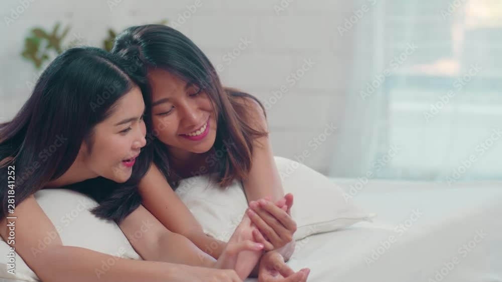 Asian Lesbian lgbtq women couple talking on bed at home. Young Asia lover female happy relax rest together after wake up while lying on bed in bedroom at home in the morning concept. Slow motion. Asian Lesbian lgbtq women couple talking on bed at home. Young Asia lover female happy relax rest together after wake up while lying on bed in bedroom at home in the morning concept. Slow motion.