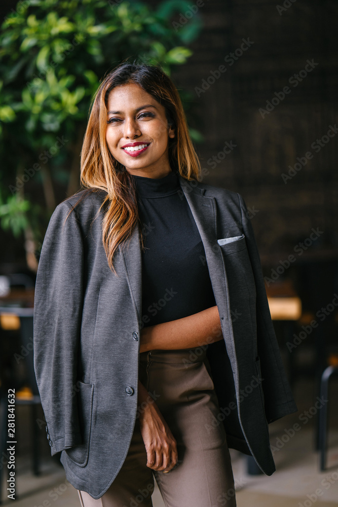 Portrait of a fashionable, capable and confident Southeast Asian woman in the city during the day. She is young, attractive and wearing a black turtleneck, khakis and has a jacket over her shoulders. Portrait of a fashionable, capable and confident Southeast Asian woman in the city during the day. She is young, attractive and wearing a black turtleneck, khakis and has a jacket over her shoulders.