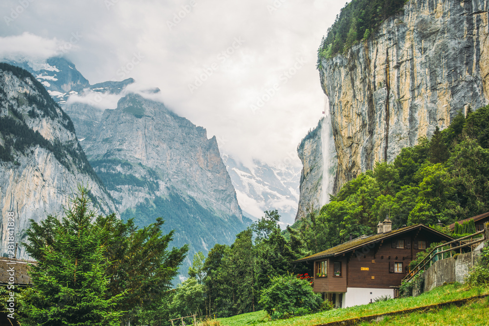 The town Lauterbrunnen in Switzerland with one of its Waterfalls in a summer landscape